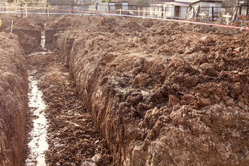 trench dug by hand for Foundation or for drainage laying and stretched rope lines for smooth digging
