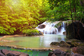 Fototapeta na wymiar Waterfall in forest with sunlight at Erawan waterfall National Park, Kanchanaburi, Thailand