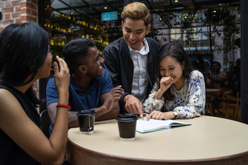 a group of multi culture friends discussing work at cafe