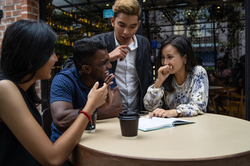 a group of multi culture friends discussing work at cafe