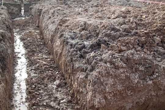 trench dug by hand for Foundation or for drainage laying and stretched rope lines for smooth digging