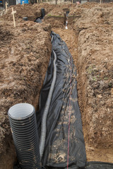 drainage pipes and inspection well for removal of water from a site under construction of the house