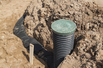 view of drainage pipes and inspection well for removal of water from a site under construction of the house