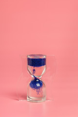 Close up of hourglass against pink background