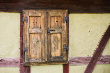 Detail of the window and wall front facade of old traditional half timbered framing house facade in Germany. The load-bearing timber is left exposed on the exterior of the building.