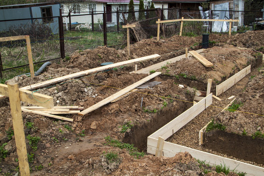 trench with pubble and formwork, which is prepared for pouring the foundation
