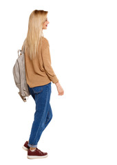 back view of walking  woman  with backpack.