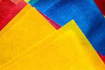 Abstract yellow, red and blue coloured paper layers macro photo as colourful texture background