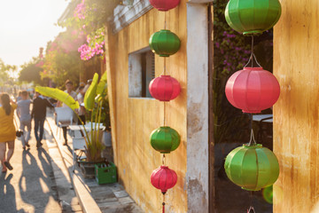 Fototapeta na wymiar Old yellow house decorated with pink and green silk lanterns