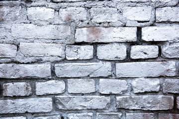 Simple white and grey brick wall painted with metallic sprayed ink paint as seamless pattern texture background.