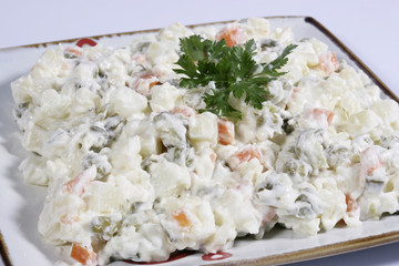 bowl of traditional russian salad on white background