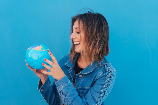 Laughing happy woman holding a world globe