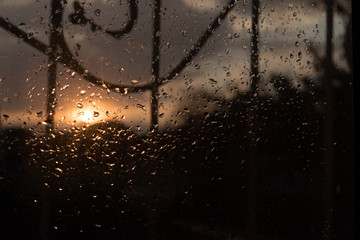 drops of rain on the glass on sunset background