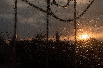 drops of rain on the glass on sunset background