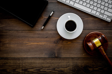 Work desk of contemporary lawyer. Lawyer office concept. Judge gavel near computer keyboard, respectable notebook on dark wooden background top view copy space
