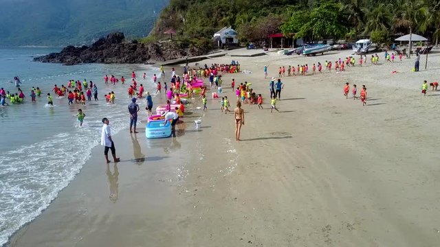 preschool children run to ocean from beach