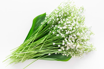 Small and fragrant spring flowers. Bouqet of lily of the valley flowers on white background top view copy space