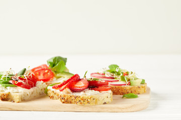 Fototapeta na wymiar various fresh sandwiches on cutting board and on white surface