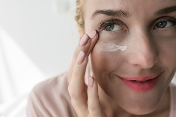 Woman Applying Creme Under Her Eye