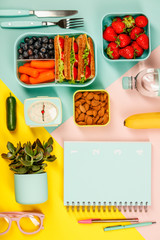 Creative flat lay with healthy lunch and office or school supplies