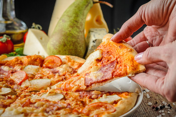 Woman's hands taking slices of pizza