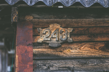 Wooden plaque on the house with number