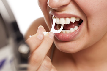  young woman cleans her teeth with a dental floss