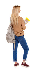 Back view of woman  with notebooks and backpack.