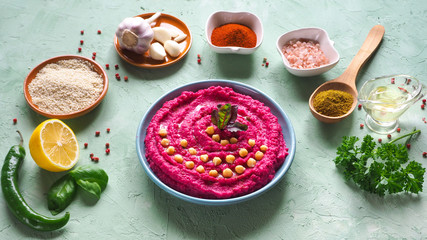 Hummus with beets on the table and ingredients for traditional hummus.