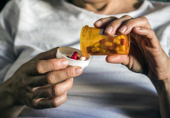 Woman examining medication treatment, several boats in the hand, conceptual image