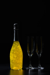 close up view of bottle of champagne and empty glasses on black background