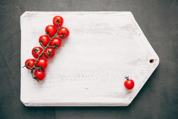 Vintage white board to write the menu and cherry tomatoes. Flat lay, top view, copy space 