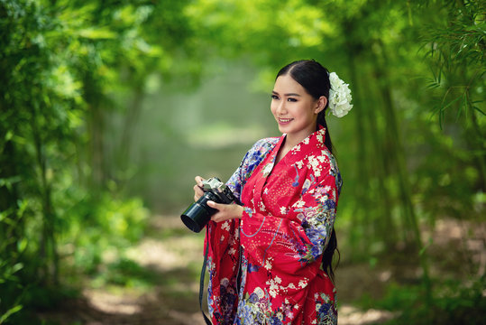 Japanese woman wearing a kimono is shooting with a camera.