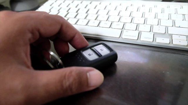 Male hand holding a wireless car key
