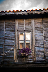 Traditional old wooden house with flowers on the windows. Nesebar, Bulgaria