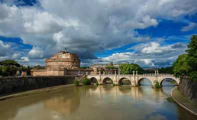 Fototapeta na wymiar Panoramic view of River Tiber with the Holy Angel Castle and Bridge under a cloudy sky in Rome