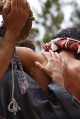Religious representation by two people of the passion of Christ, man whipped with wounds