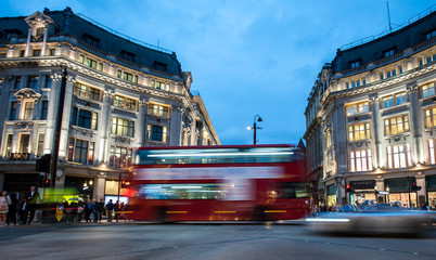 Menschen und roter Doppeldeckerbus überqueren den Oxford Circus, die belebte Kreuzung der Oxford Street und der Regent Street im West End von London