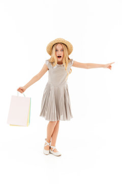 Full length image of Surprised young blonde girl in dress