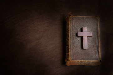 Fototapeta premium Small wooden cross and a bible on a brown table