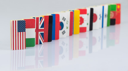 Fototapeta premium The domino effect with tiles of flags of different countries of the world. conceptual photo, political games. Studio shooting