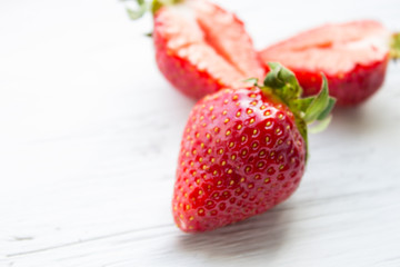 Berries of strawberries on a light wooden background. Copy space.