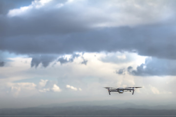 Drone quadrocopter with high resolution digital camera flying on the cloudy thunder sky