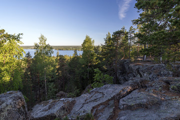 Lake, lush forest and cliff viewed from the Pirunvuori ("Devil's Mountain") on a sunny morning in the summertime in Sastamala, Southern Finland.