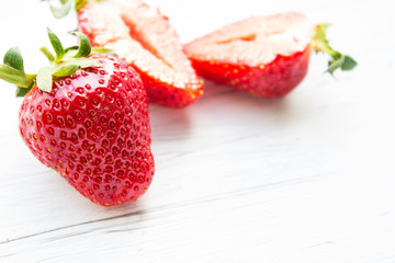 Berries of strawberries on a light wooden background. Copy space.