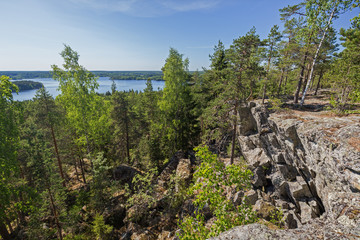 Lake, lush forest and rocky hill viewed from the rocky hilltop of Pirunvuori ("Devil's Mountain") on a sunny day in the summertime in Sastamala, Southern Finland.