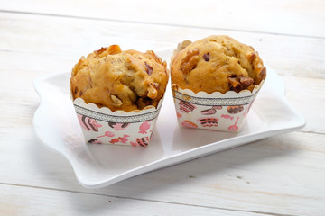 Banana pecan muffin on white wooden background