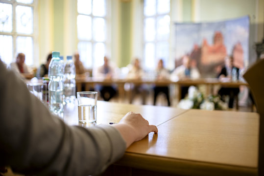 People At A Round Table Discuss Different Issues. Focus On Hand