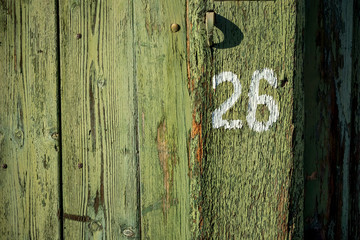 Number 26 on old green painted wooden door