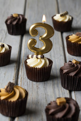 Number 3 celebration birthday cupcakes on a wooden background